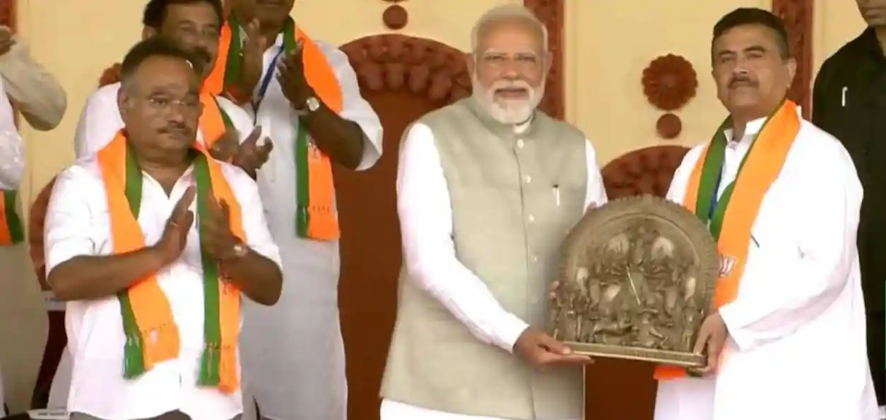 প্রধানমন্ত্রী নরেন্দ্র মোদির হাতে স্মারক তুলে দেন বিরোধী দল নেতা শুভেন্দু অধিকারী। পাশে বিজেপির রাজ্য সভাপতি শমীক ভট্টাচার্য